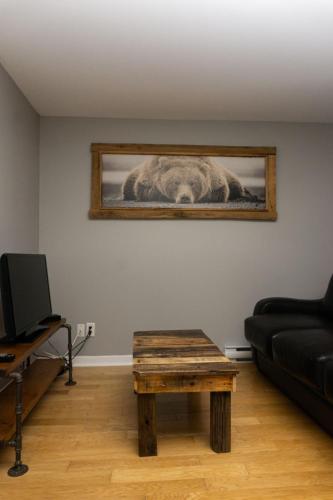 a living room with a picture of a horse on the wall at Condo Hotel Au pied du Mont Orford in Orford