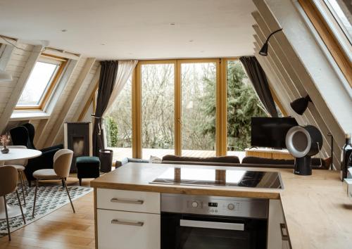 a kitchen and living room in a house with windows at Naturhaus am Felsenweg in Mitlosheim