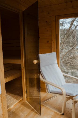 a white chair in a room with a window at Naturhaus am Felsenweg in Mitlosheim