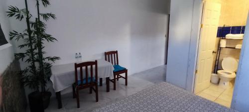 Zimmer mit einem Tisch, 2 Stühlen und einem WC in der Unterkunft Playa El Obispo E La Marea building La Libertad in La Libertad