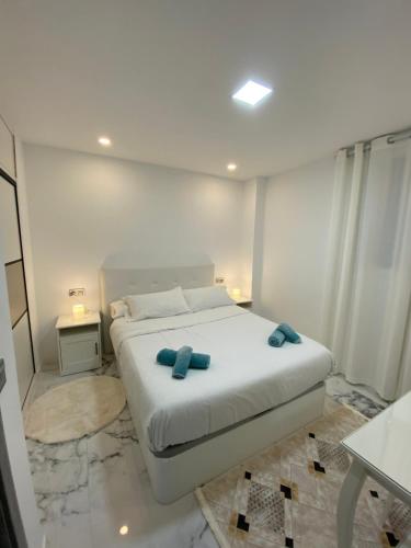 a bedroom with a bed with blue pillows on it at Beach apartment Palma Center in Palma de Mallorca