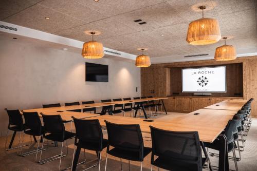 a large conference room with a large wooden table and chairs at Hôtel de la Roche in Beaufort