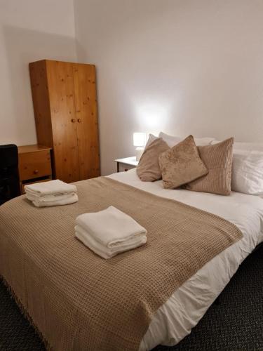 ein Schlafzimmer mit einem Bett mit zwei Handtüchern darauf in der Unterkunft Shortridge Terrace - 2 in Jesmond