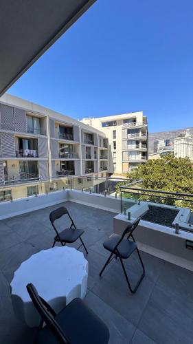 dos sillas y una mesa en el techo de un edificio en dockrail and cast anchor drive Apartment, en Ciudad del Cabo