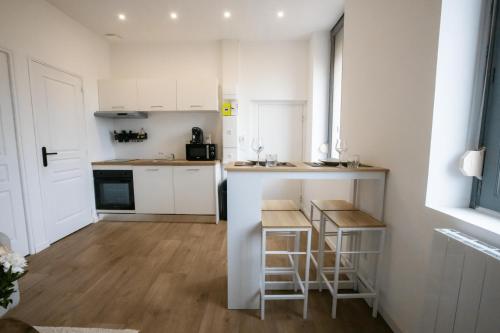 a small kitchen with white cabinets and a counter at Appartement - Centre ville de Cambrai in Cambrai