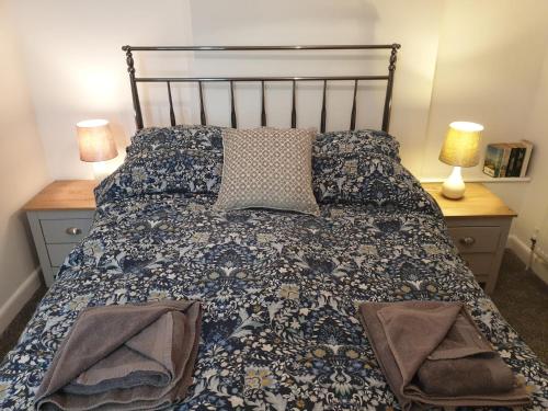 Ty Twt في ريكسهام: سرير في غرفة نوم مع مصباحين وطاولتين