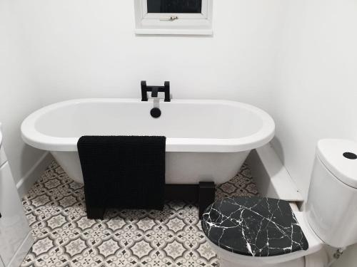 Ty Twt في ريكسهام: حمام أبيض مع حوض ومرحاض