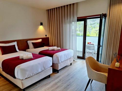 ein Hotelzimmer mit 2 Betten und einem Balkon in der Unterkunft 3M Hostel & Suites in Alvaiázere