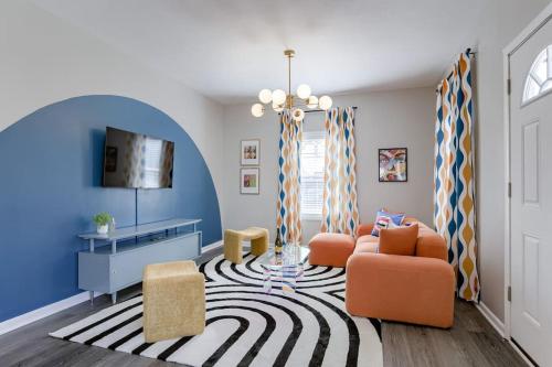 a living room with orange chairs and a blue wall at UNL Retreat Eclectic 5bd 5mins to Downtown in Lincoln