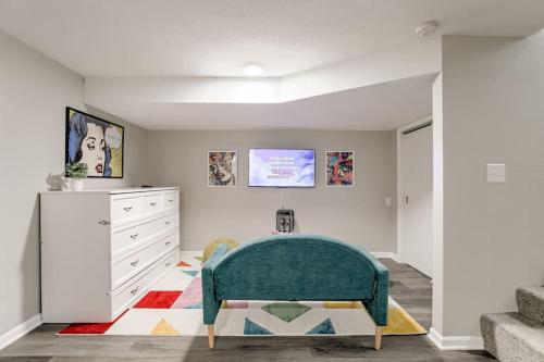 a living room with a green couch and a dresser at UNL Retreat Eclectic 5bd 5mins to Downtown in Lincoln