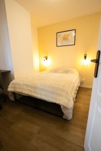 Ce lit se trouve dans un dortoir doté de 2 lumières sur le mur. dans l'établissement Appartement - Centre ville de Cambrai, à Cambrai