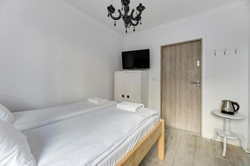 um quarto branco com uma cama e uma pequena mesa em Grobla Centrum 2 by Grand Apartments em Gdansk