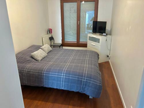 une petite chambre avec un lit et une télévision dans l'établissement Village olympique, à Saint-Denis