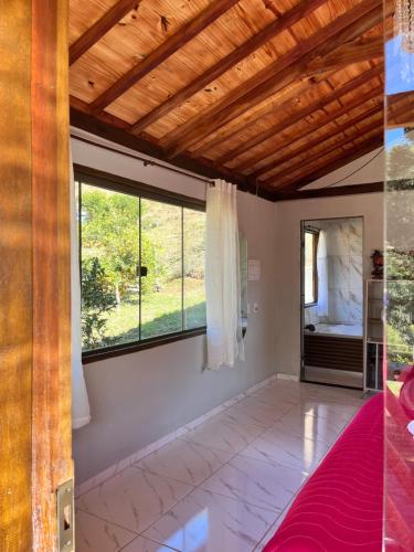 Hospedagem Florenza في أيوريوكا: غرفة نوم بسقف خشبي ونوافذ كبيرة