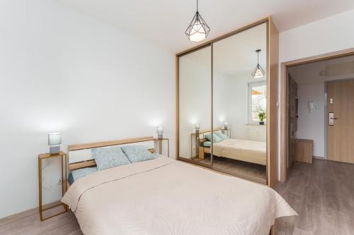 a bedroom with a bed and a large mirror at Apartament Miodowy Dom Kołobrzeg in Kołobrzeg