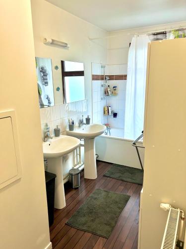 une salle de bain avec deux lavabos et une baignoire dans l'établissement Village olympique, à Saint-Denis