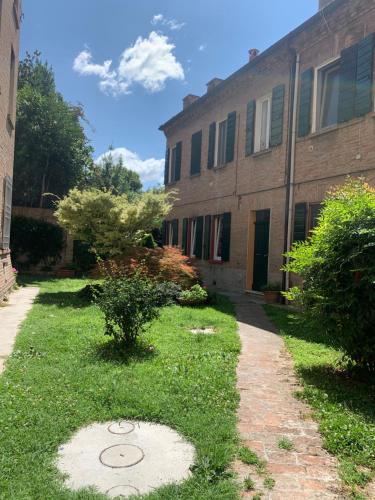 a building with a grass yard in front of a building at Biciclò Mini Studio in Ferrara