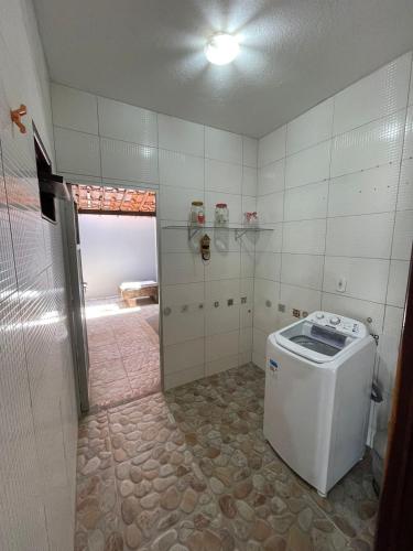 uma casa de banho com uma máquina de lavar roupa num quarto em Casa de praia Amarópolis em Paripueira