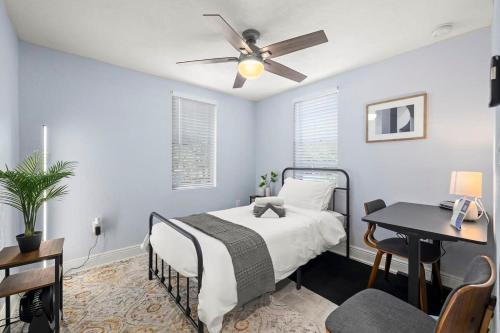 1 dormitorio con cama, escritorio y ventilador de techo en Entire House~Huge Backyard~Sleeps 5~ 3 beds 2 bath, en Tampa