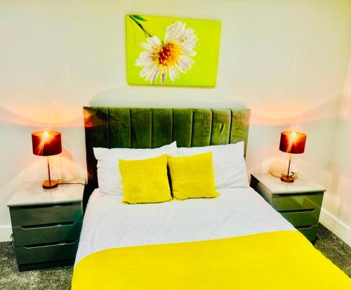 a bedroom with a yellow bed with two lamps at Icare Lodge Ltd,Safwaan House. in Barking