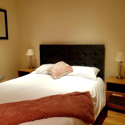 a bedroom with a large bed with a black headboard at Carter House in Bradshaw