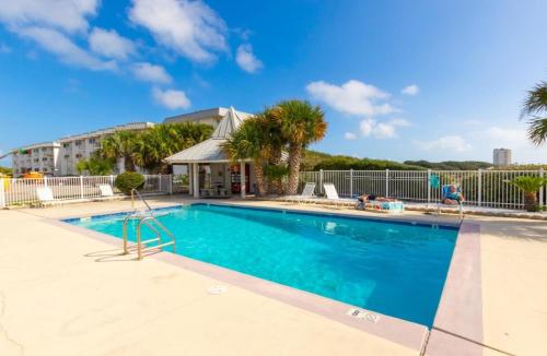 einen Pool in einem Resort mit Palmen in der Unterkunft Gulf Shores Plantation Unit 4310 in Gulf Highlands