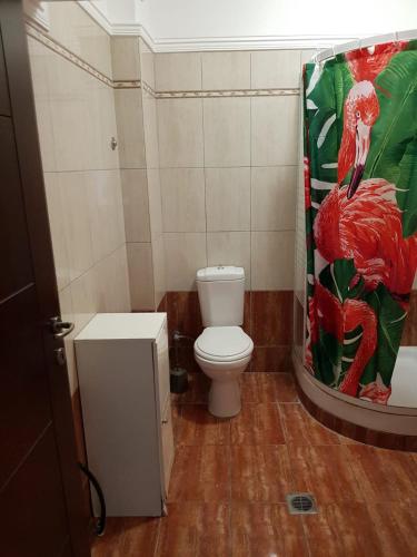 a bathroom with a toilet and a shower curtain at Kriopigi Apartments 2 in Kriopigi