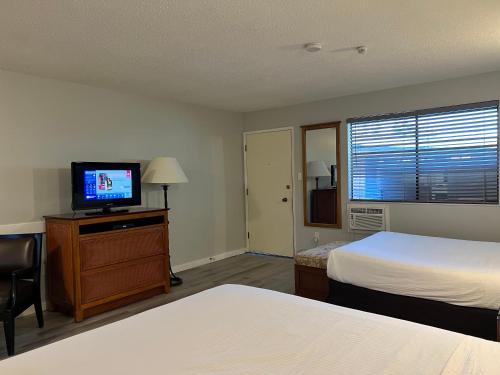 Habitación de hotel con 2 camas y TV de pantalla plana. en VIP Motel, en Parksville