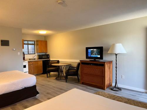 a hotel room with a bed and a television and a kitchen at VIP Motel in Parksville