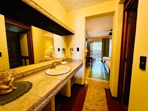baño con lavabo y espejo grande en Lake Arenal Brewery & Hotel, en Tilarán
