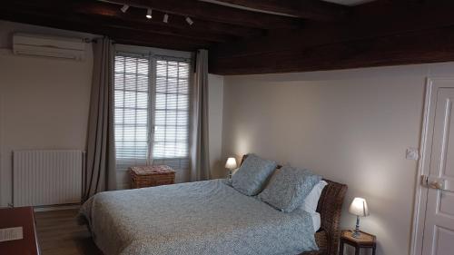 - une chambre avec un lit doté d'oreillers bleus et d'une fenêtre dans l'établissement Le Logis de Stofflet, à Maulévrier