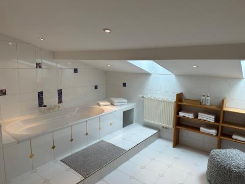 ein großes Bad mit einer Badewanne und einem Waschbecken in der Unterkunft 17er Apartment mit Sauna und privater Garage in Mondsee