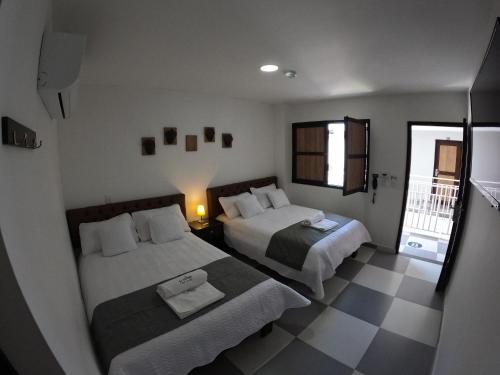 a bedroom with two beds and a checkered floor at Hotel El Olimpo in Santa Marta