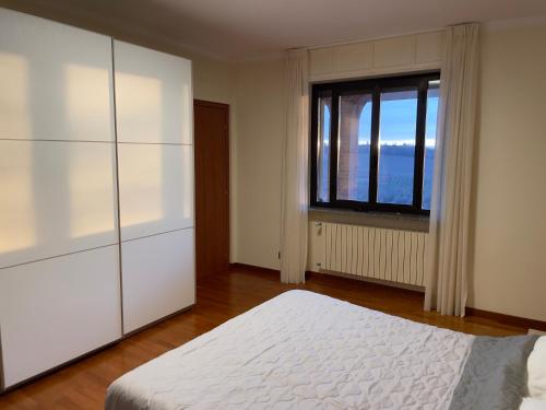 a bedroom with a white bed and a window at Landora in Grazzano Badoglio