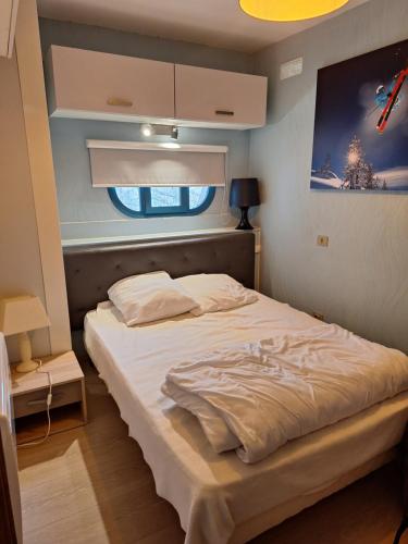 une chambre avec un grand lit avec une fenêtre dans l'établissement Appartement les Orres 1650, aux Orres