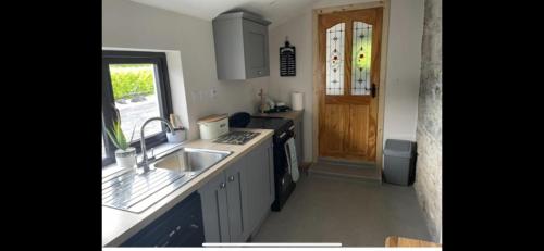 a kitchen with a sink and a stove at Kate’s Cottage in Westport
