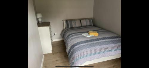 a small bedroom with a bed with a striped blanket at Kate’s Cottage in Westport