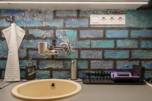 ブダペストにあるBárka Home in downtown Budaのレンガの壁、洗面台付きのバスルーム