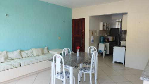 a living room with a couch and a table and chairs at Condomínio Caribe Fortaleza CE in Caucaia