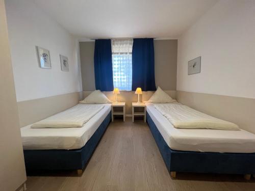 um quarto com duas camas e uma mesa com dois candeeiros em Hotel Pelikan em Kitzingen