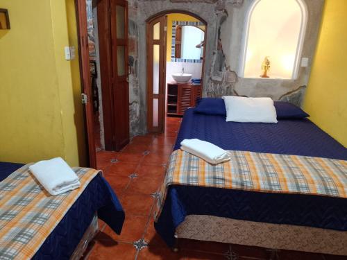 Habitación de hotel con 2 camas y baño en hotel posada Gutierrez antigua, en Antigua Guatemala