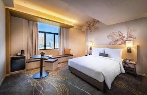 Hilton Garden Inn Kuala Lumpur - North في كوالالمبور: غرفة فندقية بسرير كبير ونافذة