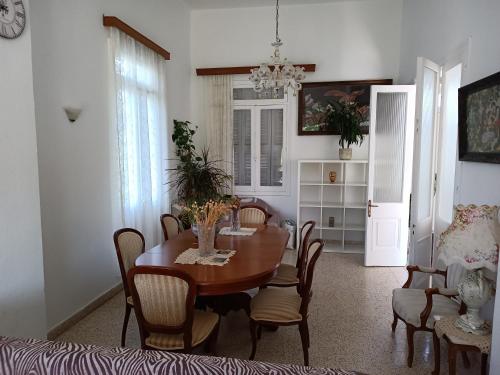 una sala da pranzo con tavolo e sedie di Tower traditional pool villa a Kremasti