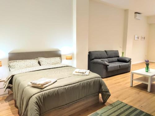 ein Schlafzimmer mit einem großen Bett und einem Sofa in der Unterkunft Apartamento entero en Valencia in Valencia