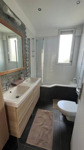 une salle de bain avec un lavabo, une baignoire et des toilettes dans l'établissement Le relais des JO 2024, à Colombes