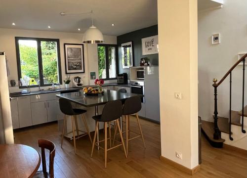 une cuisine avec une table et des chaises dans une pièce dans l'établissement Le relais des JO 2024, à Colombes