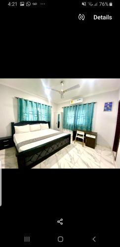 ein Schlafzimmer mit einem Bett und einem Tisch darin in der Unterkunft Accra City Apartments in Accra
