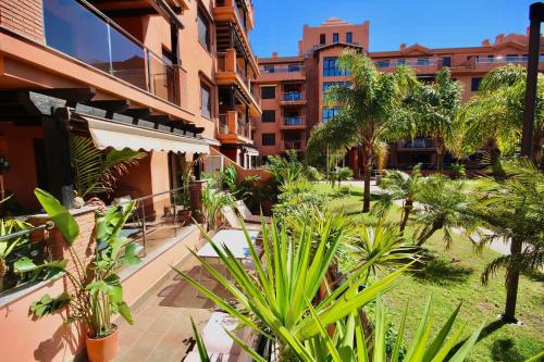 um pátio com palmeiras e um edifício em Dos Mares Apartamentos Playa Granada em Motril