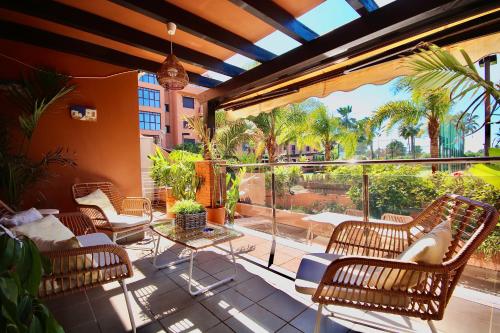 un patio esterno con sedie e una grande finestra di Dos Mares Apartamentos Playa Granada a Motril