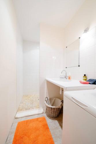 une salle de bain blanche avec un lavabo et un miroir dans l'établissement Maison Besun, à Dieulefit